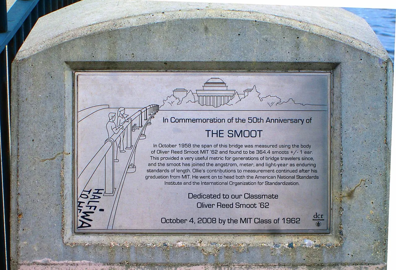 A stone plaque on the Harvard Bridge commemorating the 50th anniversary of the smoot, dedicated to Oliver Reed Smoot by the MIT Class of 1962.